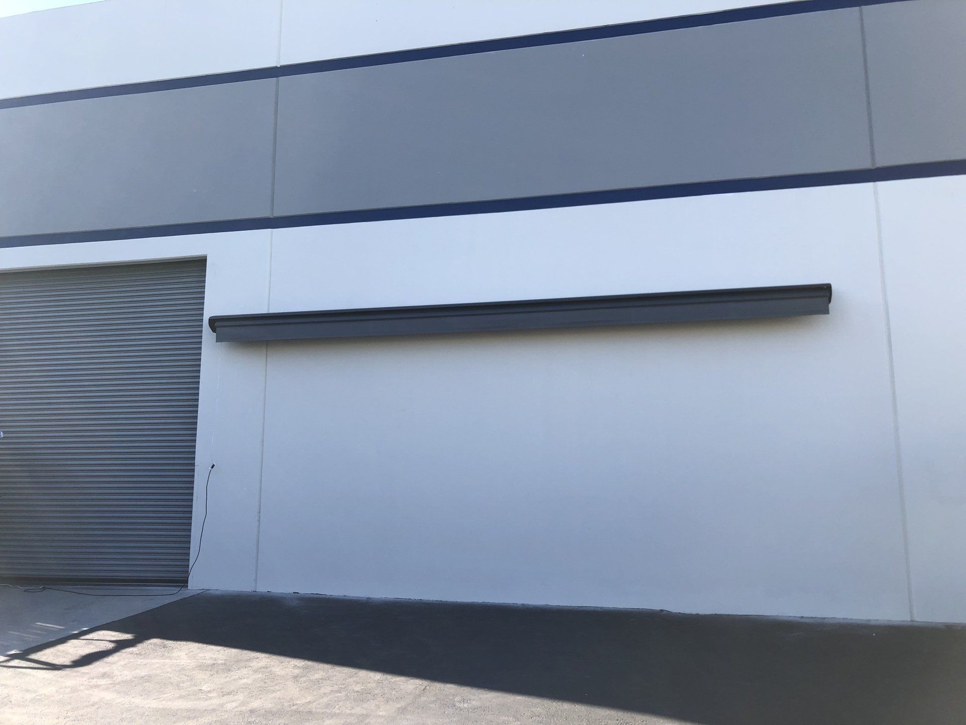 A white building with a gray stripe on the side