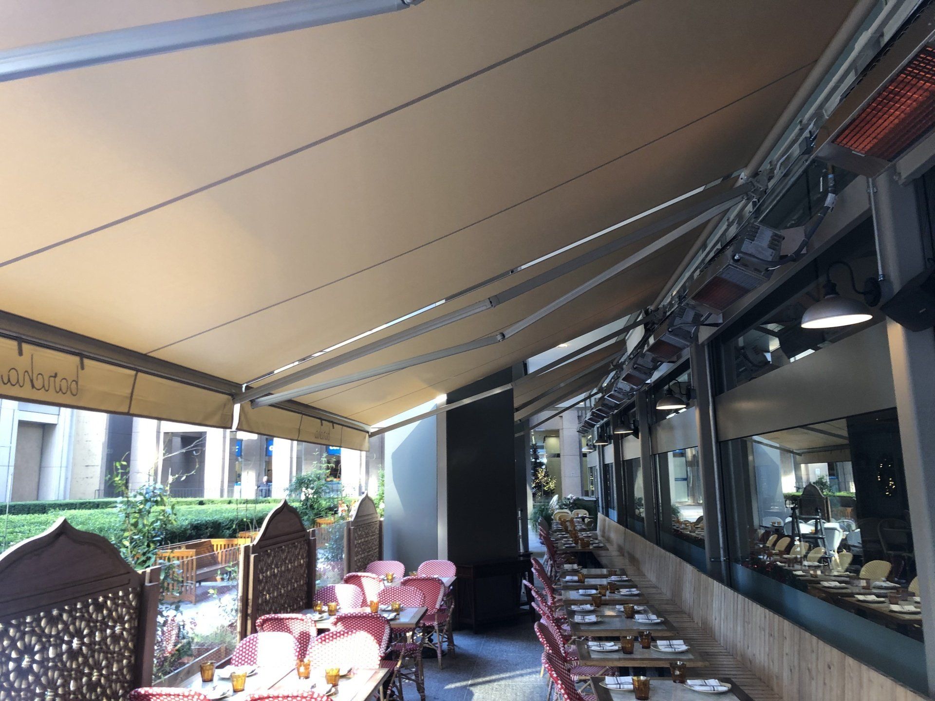 A restaurant with tables and chairs under an awning