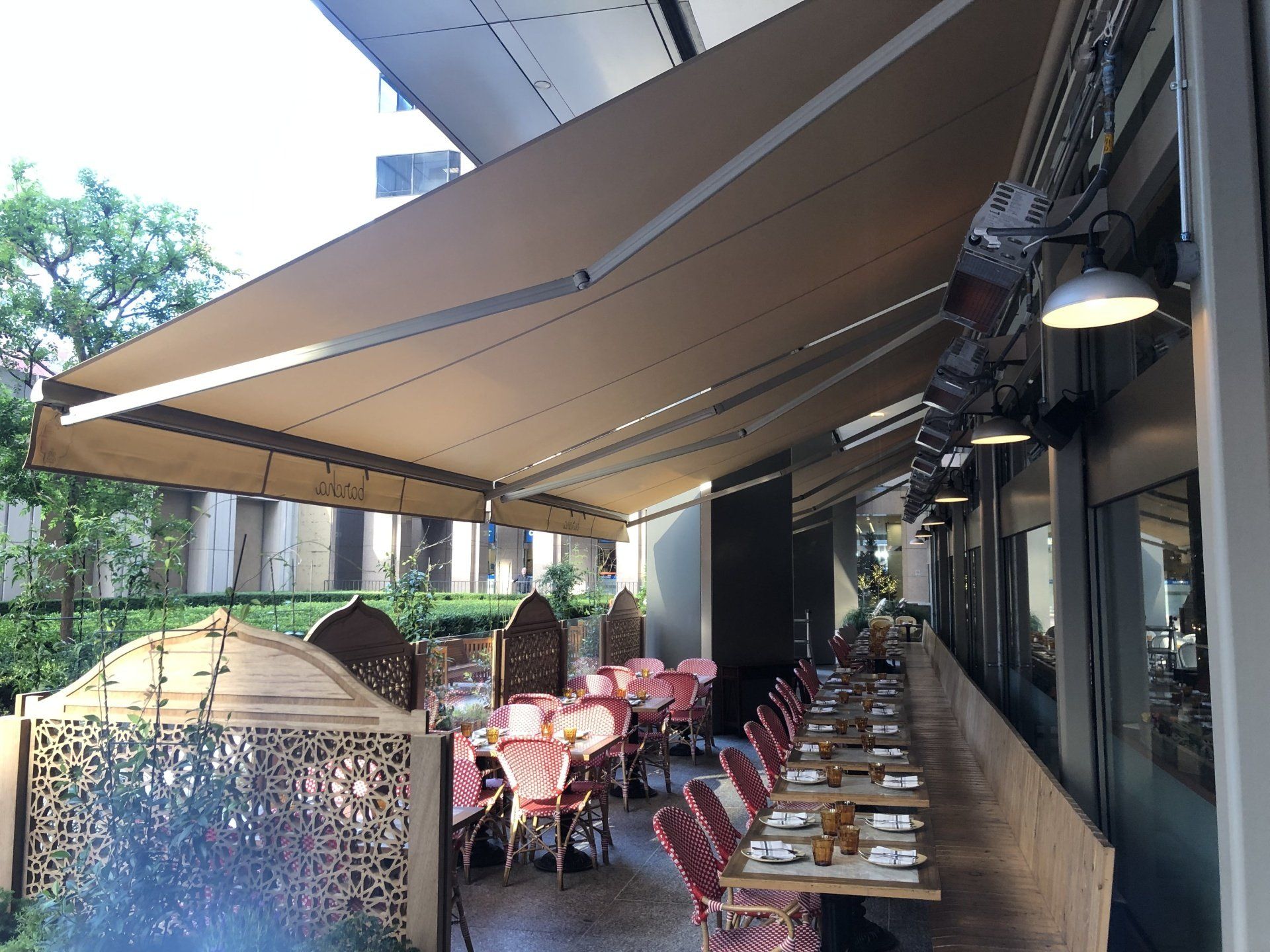 A restaurant with tables and chairs under an awning