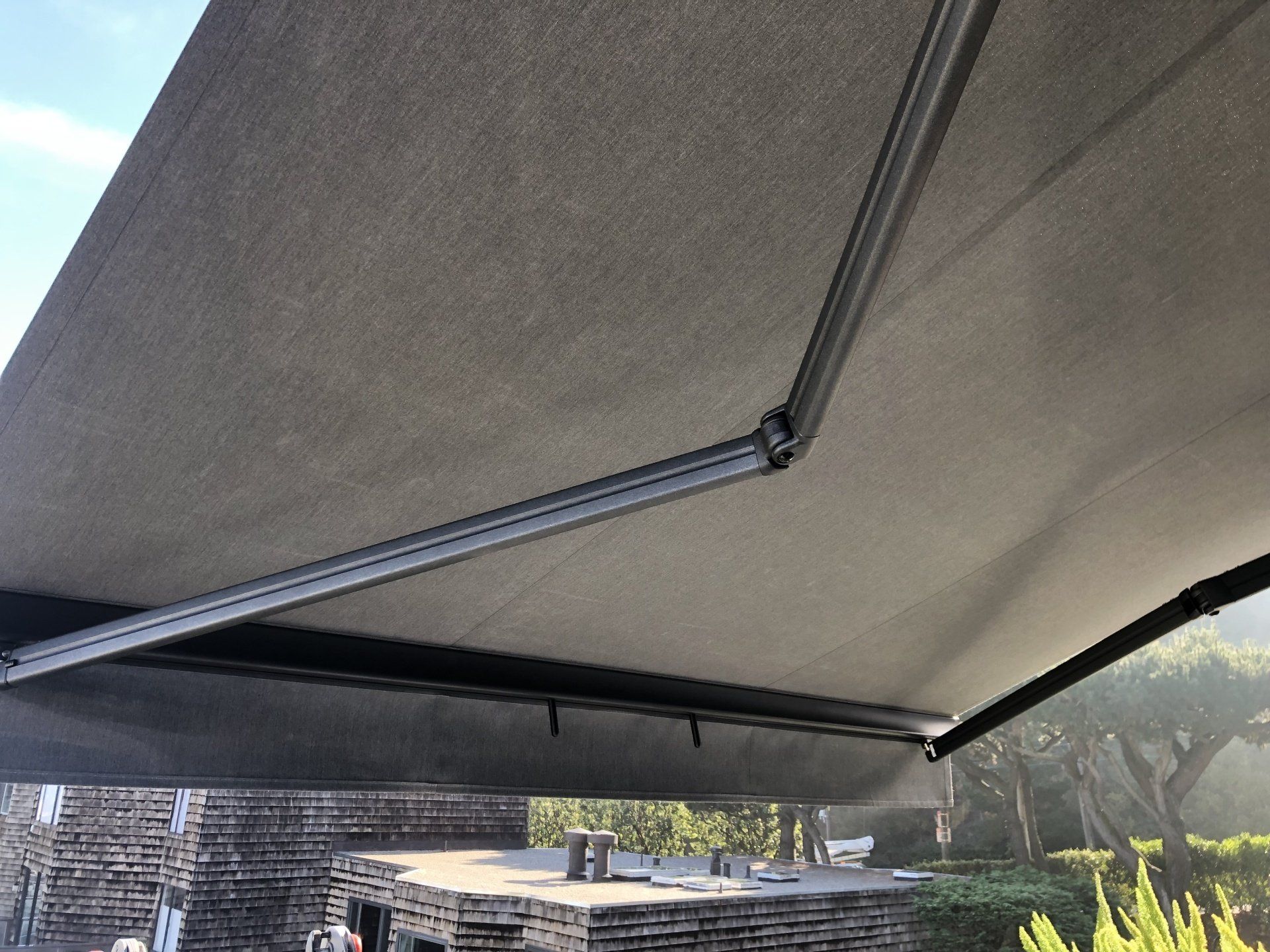 A gray awning is sitting on top of a brick building.