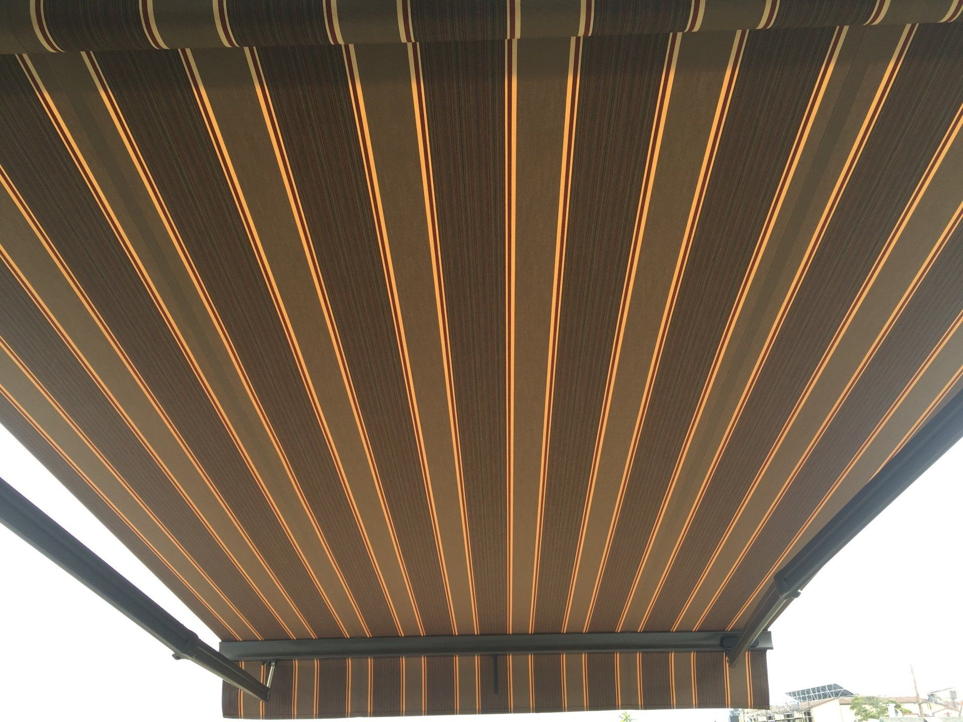 A brown and tan striped awning with a black frame