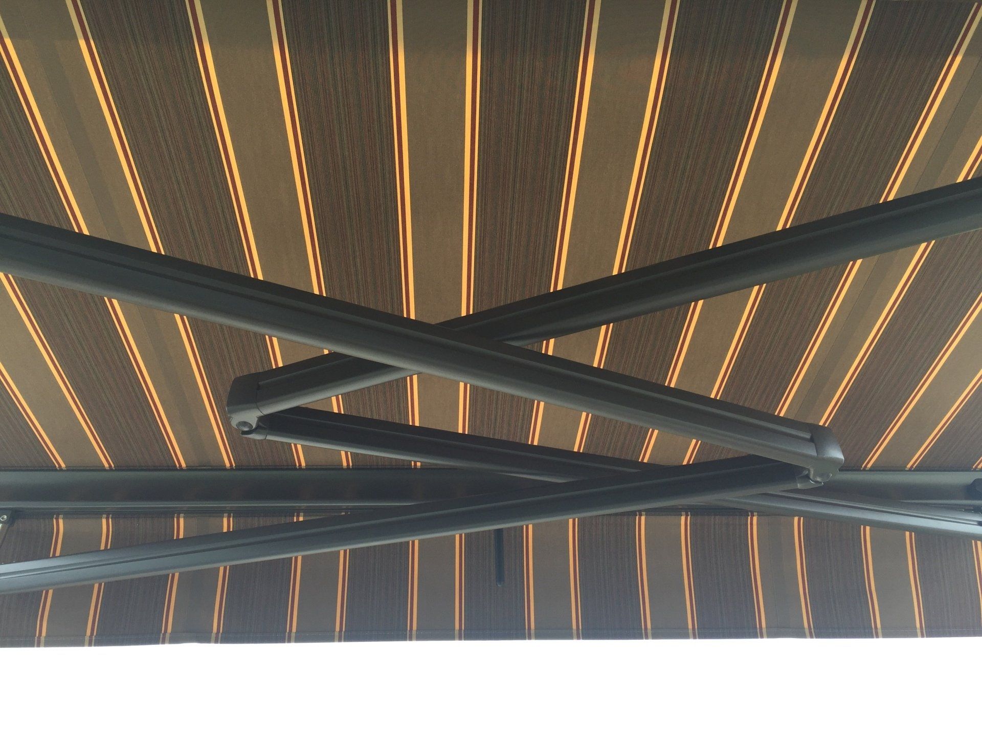 A close up of a striped awning with a metal frame