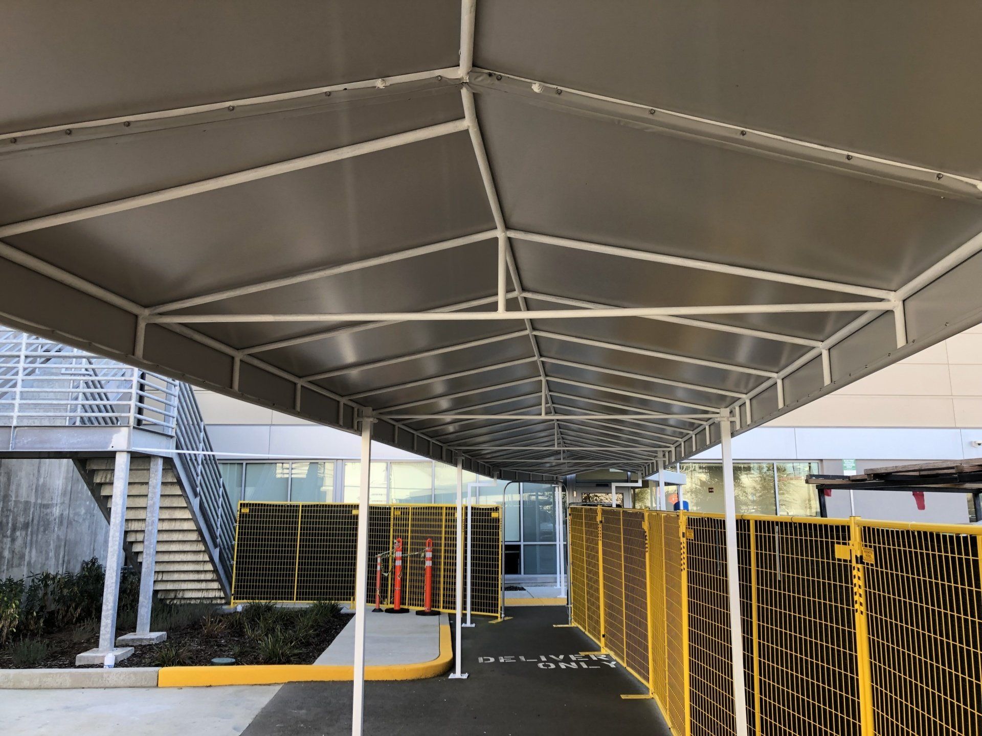 A canopy over a walkway leading to a building