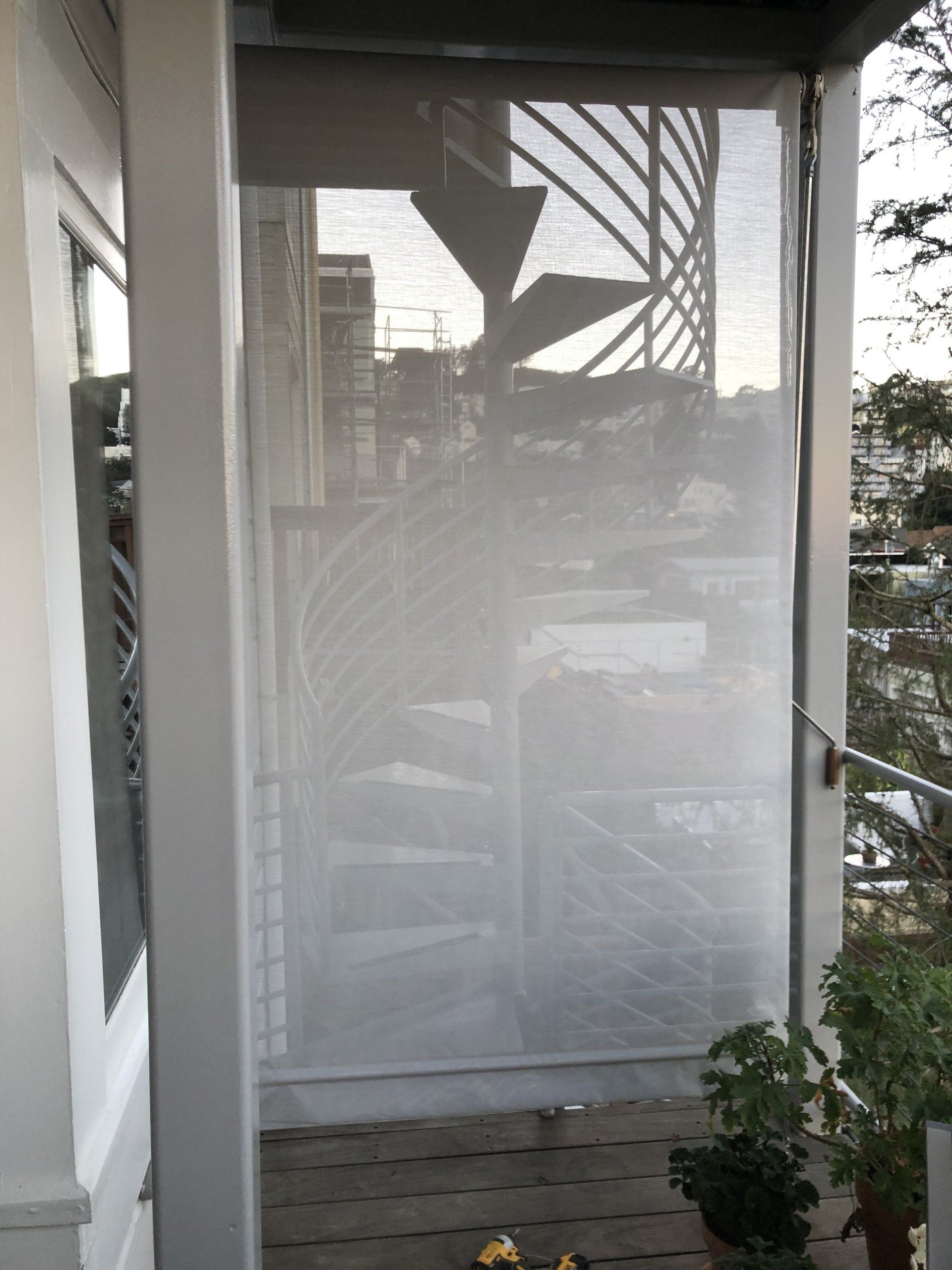 A staircase is visible through a screen on a porch.
