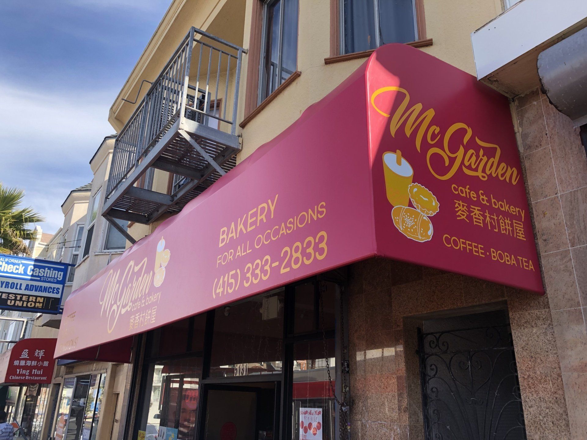 A bakery with a red awning that says mc garden