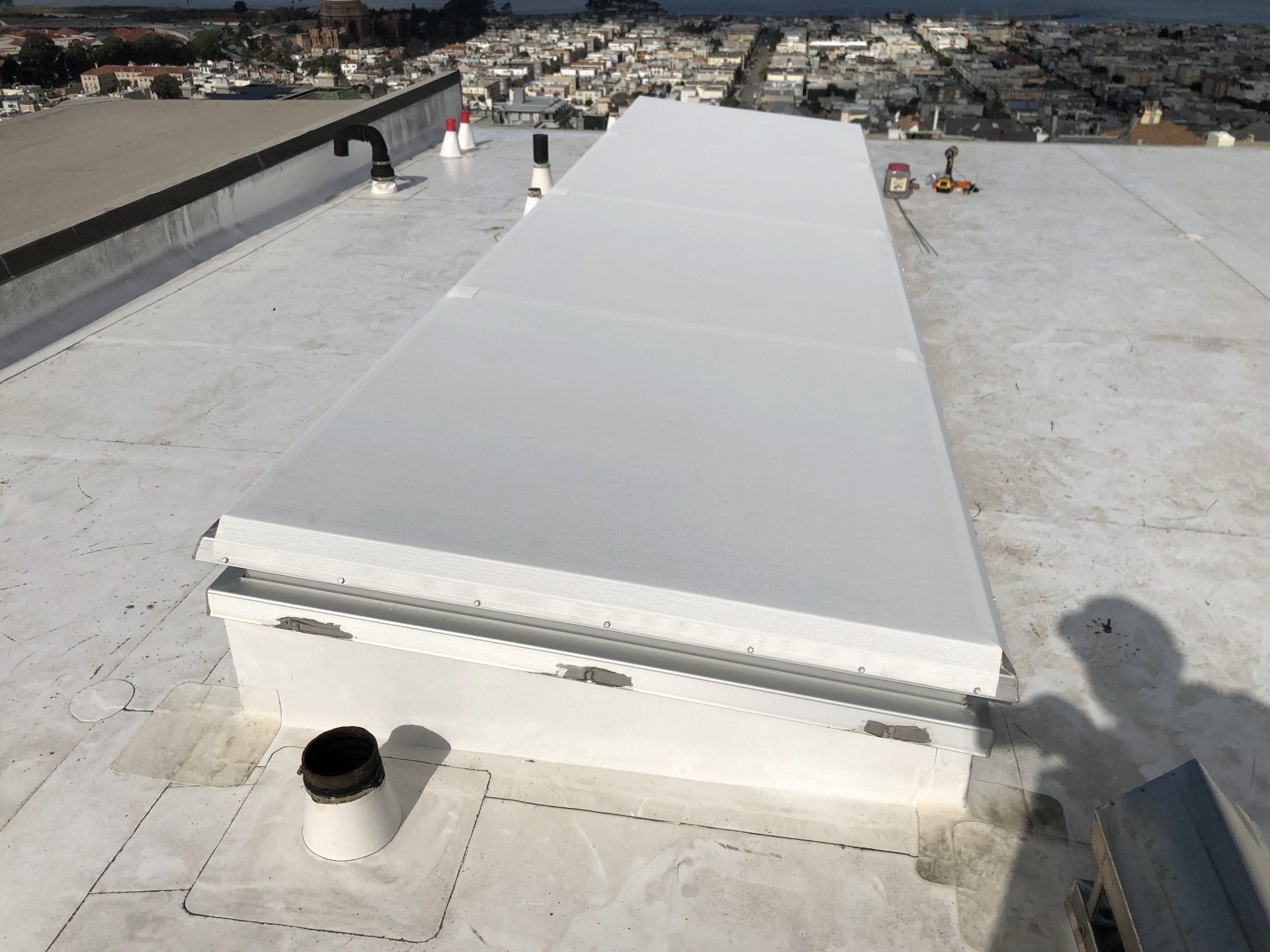 A white roof with a skylight on top of it.