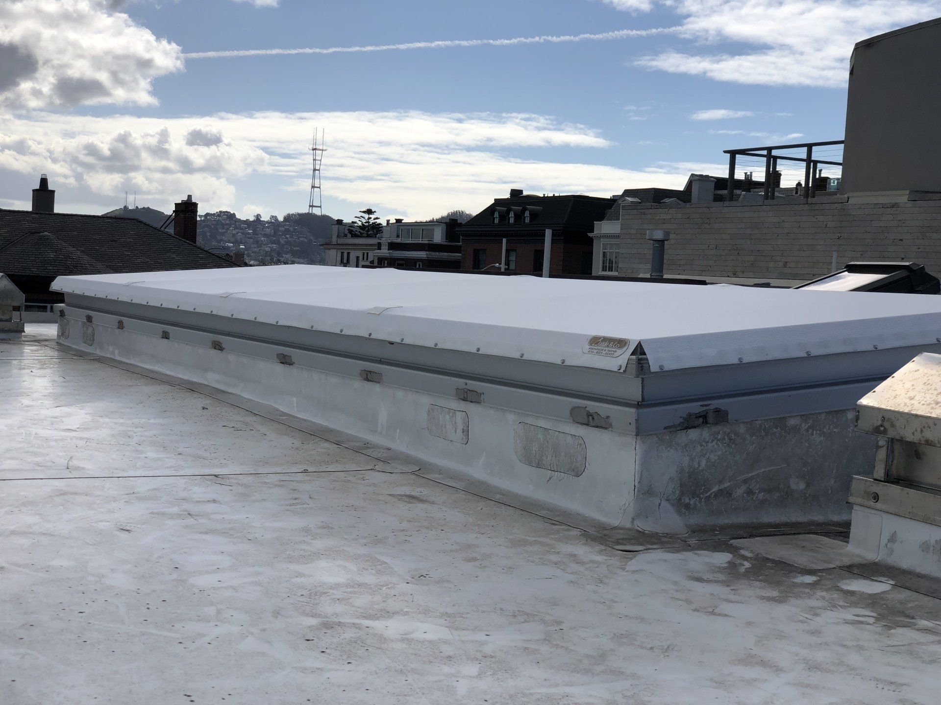 A white roof with a skylight on top of it.