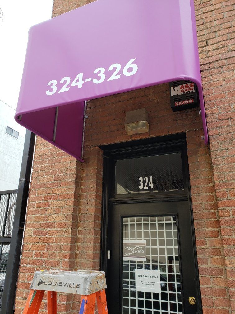 A purple awning over a door with the number 324 on it
