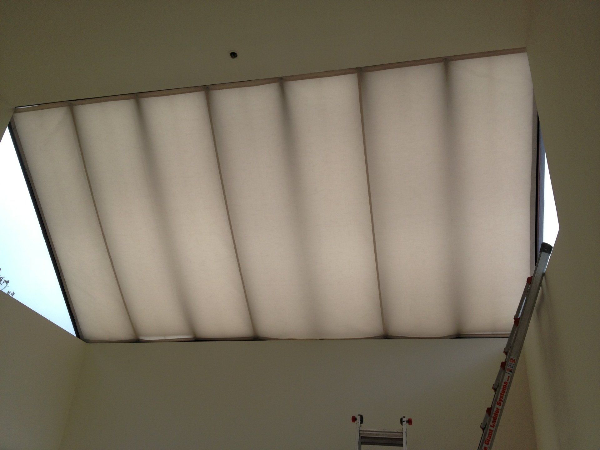 A white ceiling with a ladder going up to it