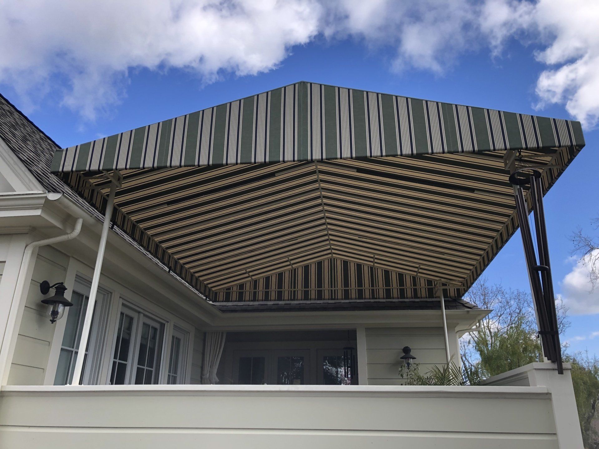 A house with a striped awning on top of it.