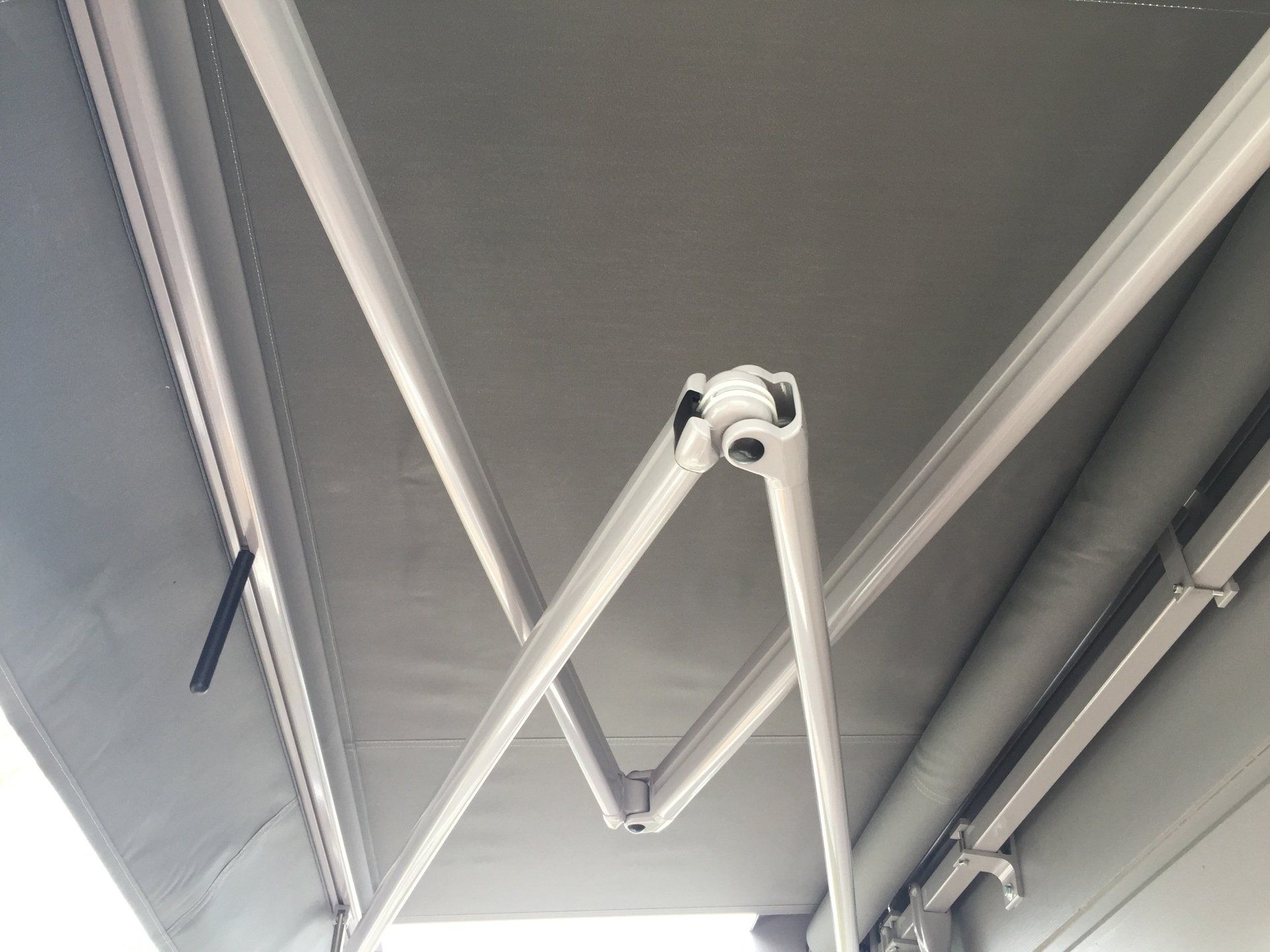 A white awning is hanging from the side of a building