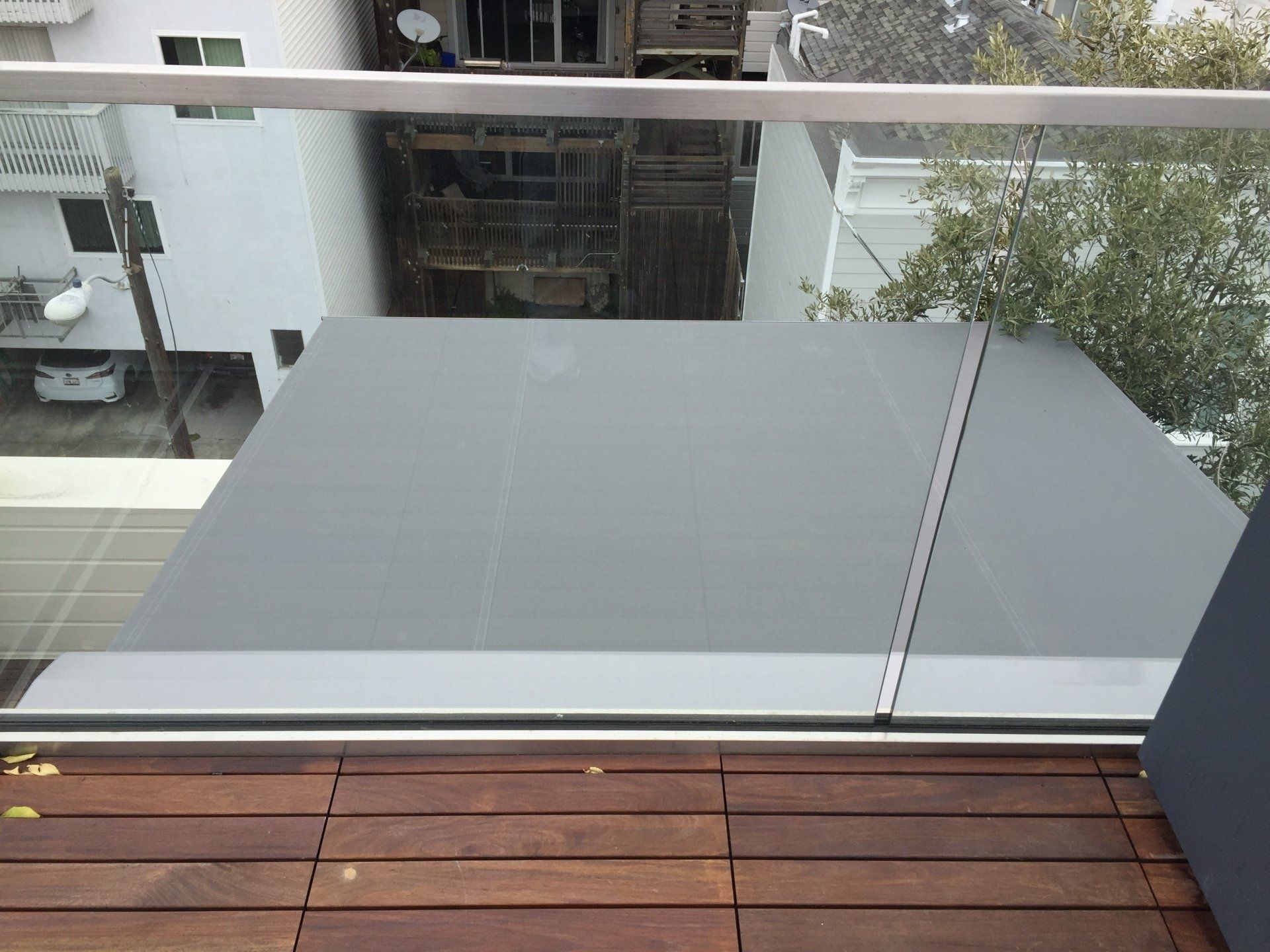A balcony with a glass railing and a wooden floor