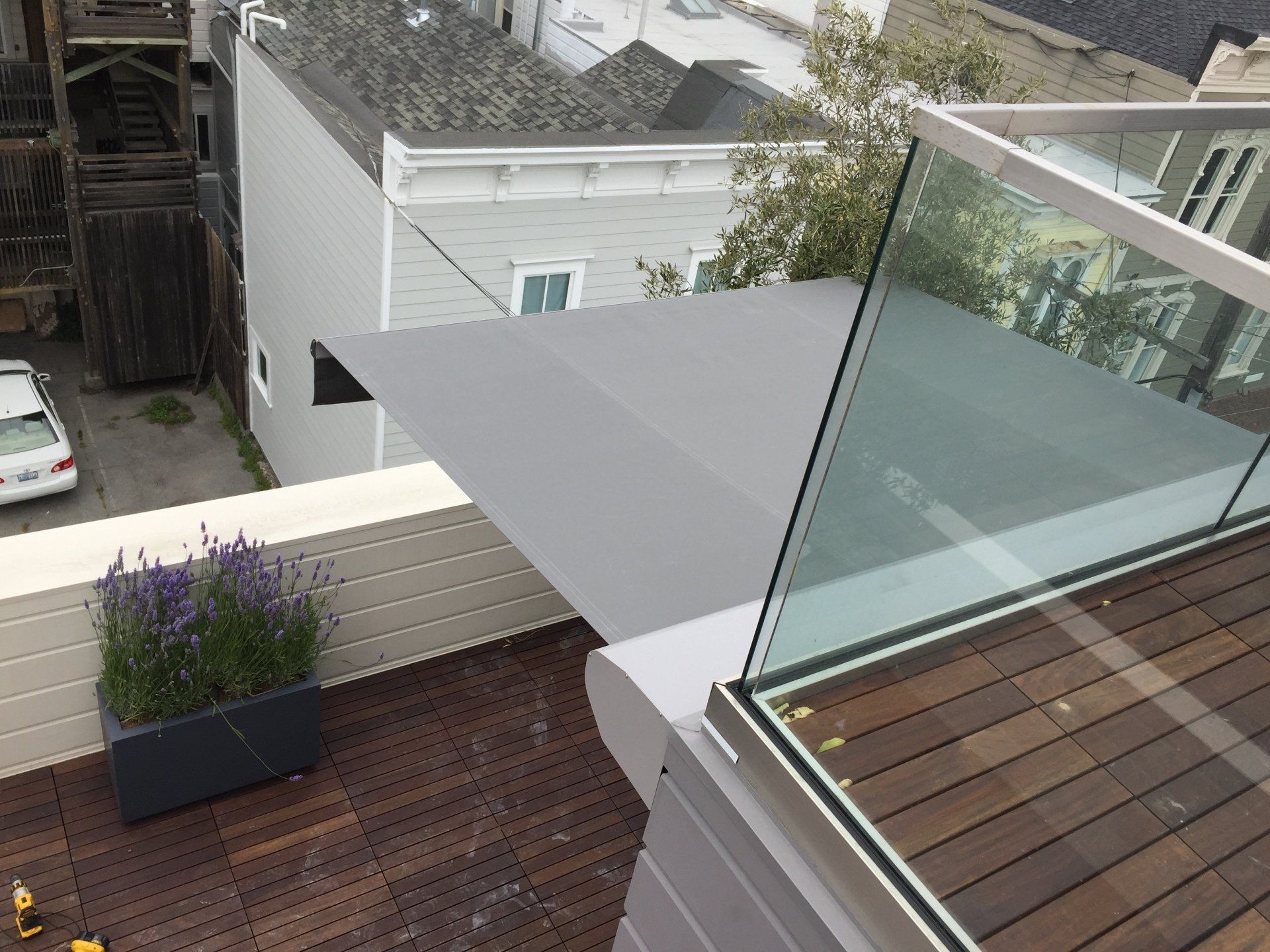 A balcony with a gray awning and a glass railing
