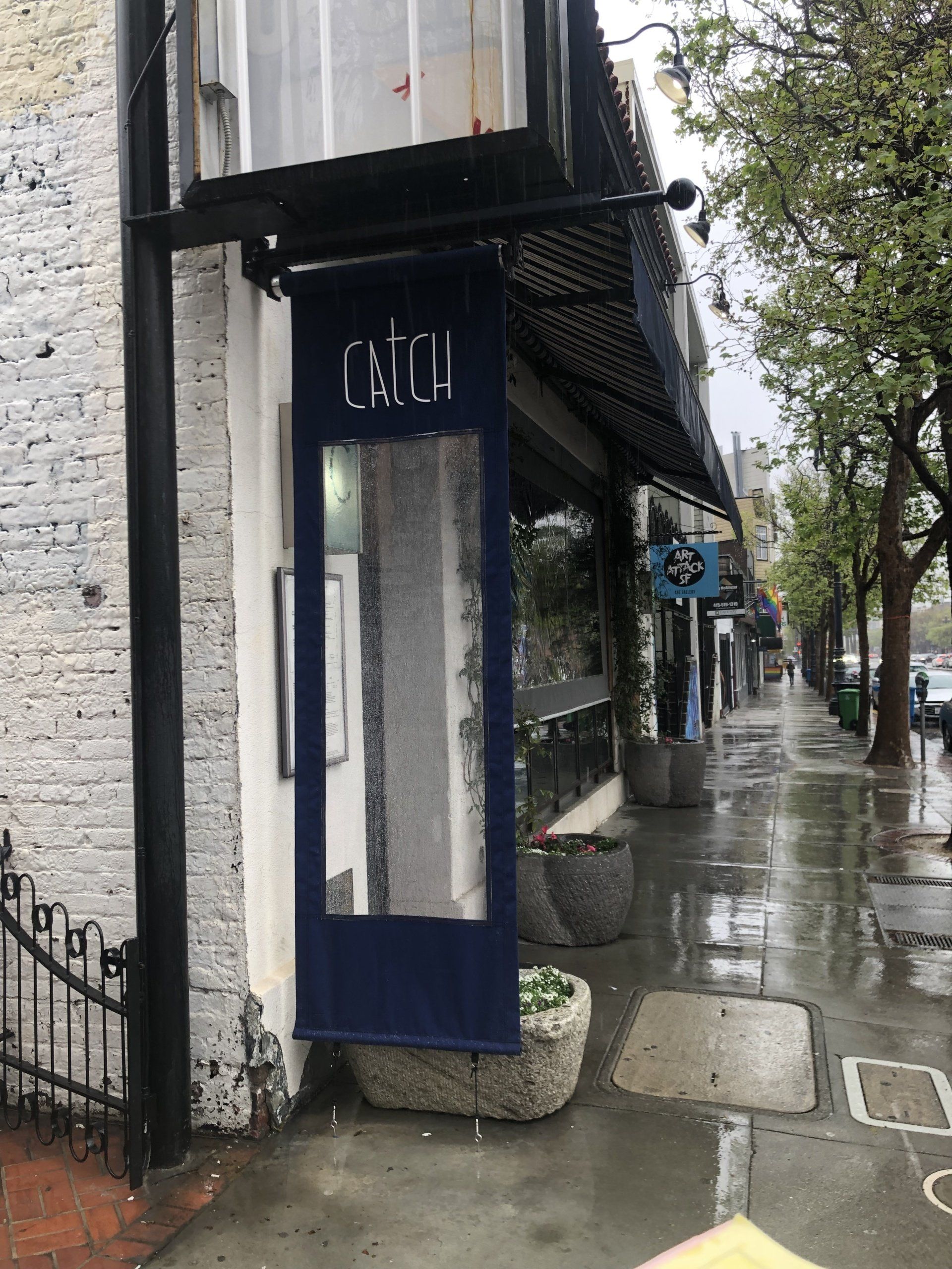 A store front with a blue awning and a sign that says catch