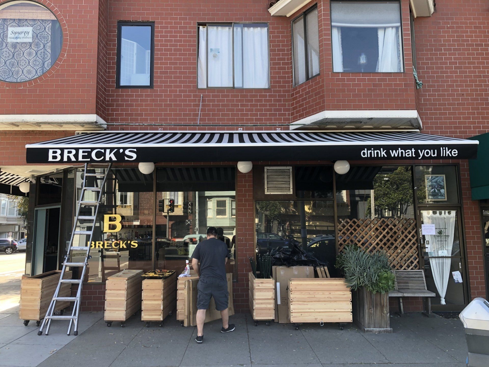 A man is standing in front of a breck 's restaurant