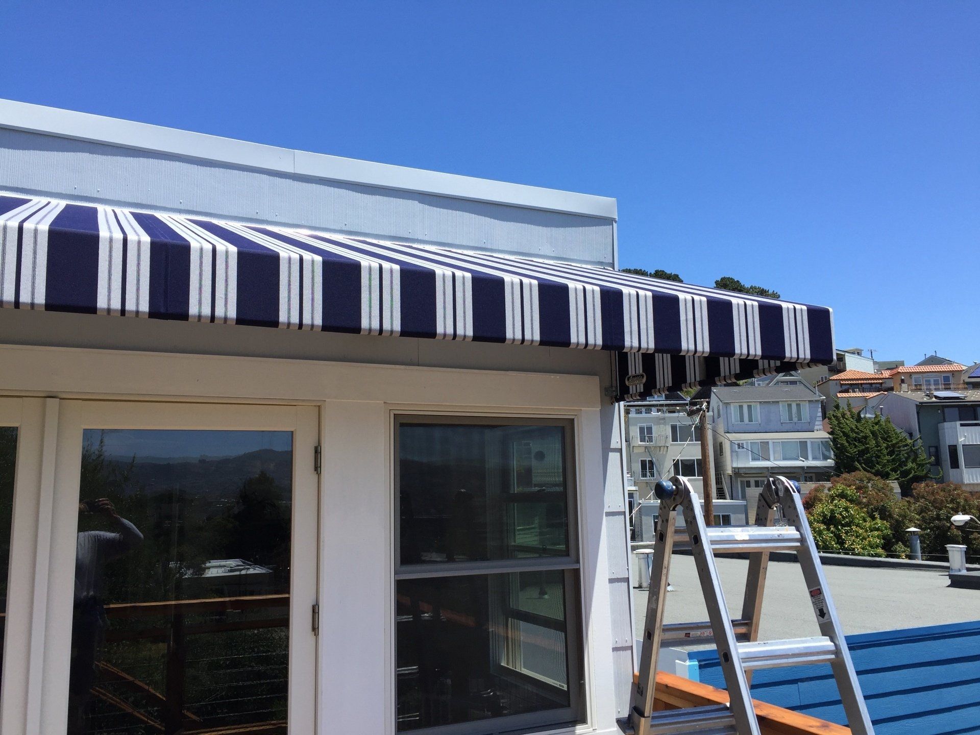 A blue and white striped awning is on the side of a building.