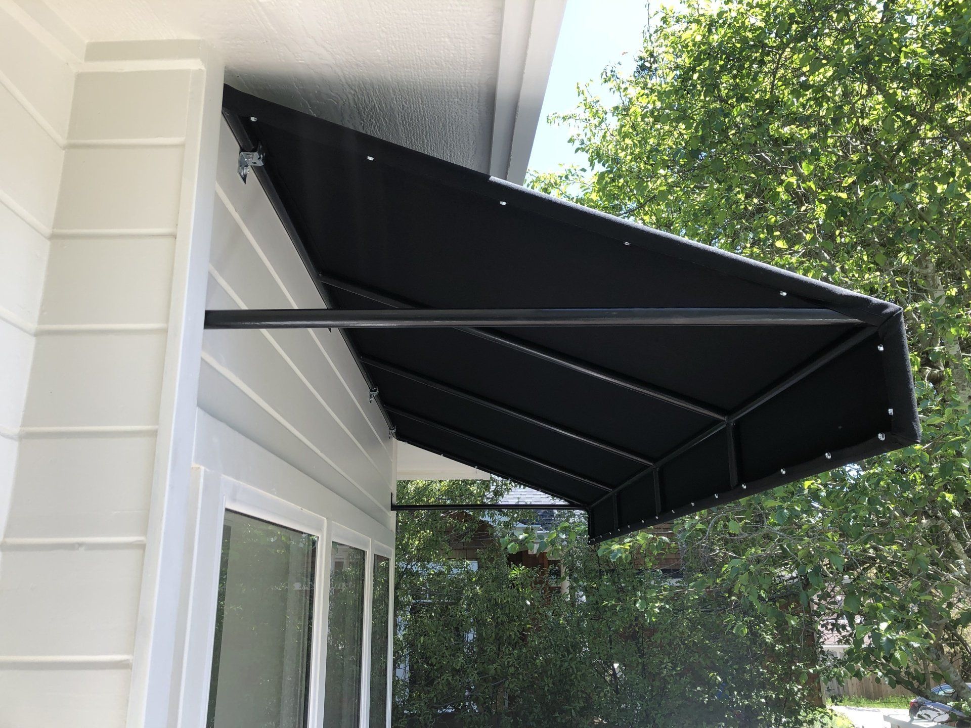 A black awning is attached to the side of a house