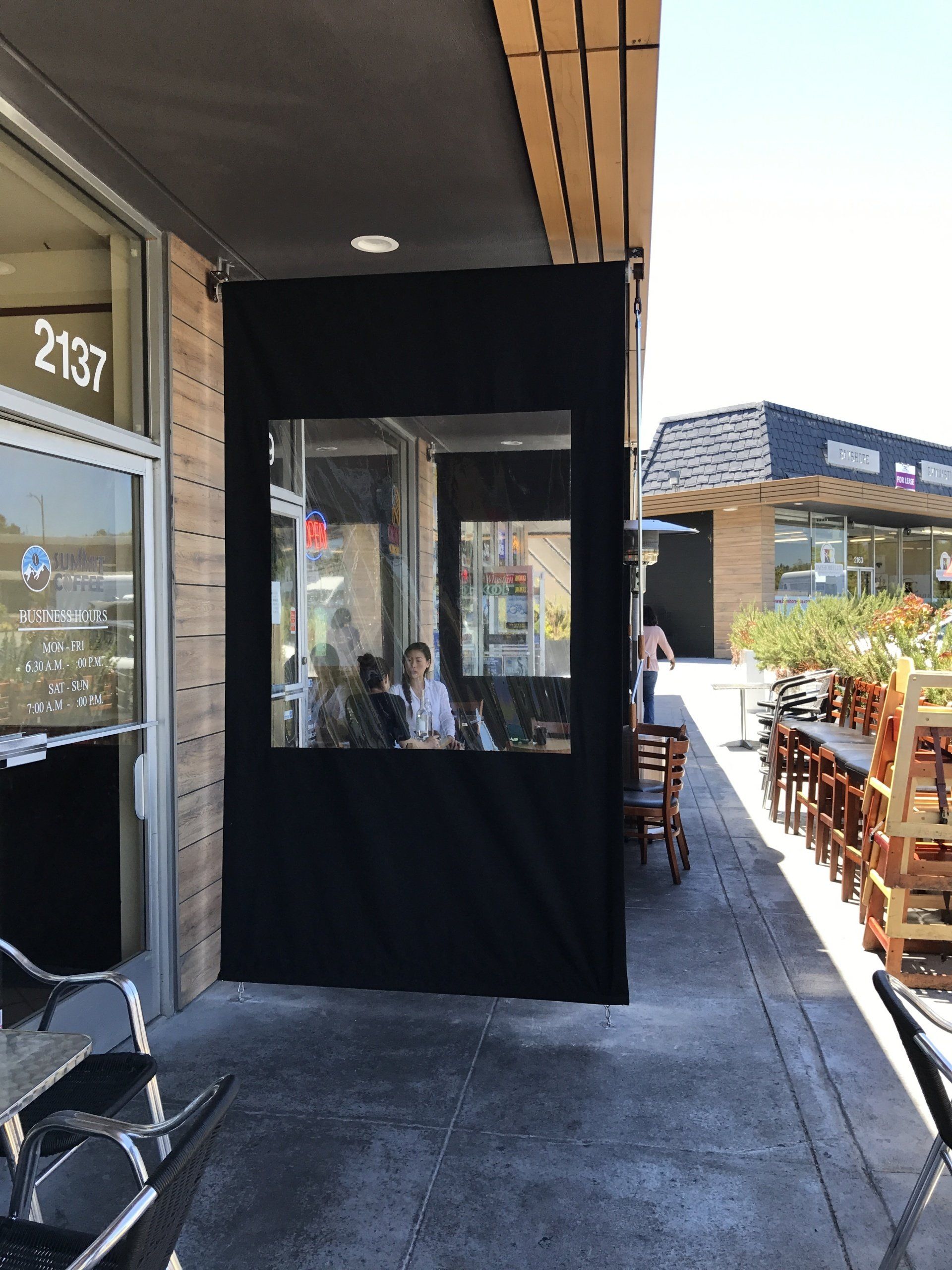 A group of people are sitting outside of a restaurant.