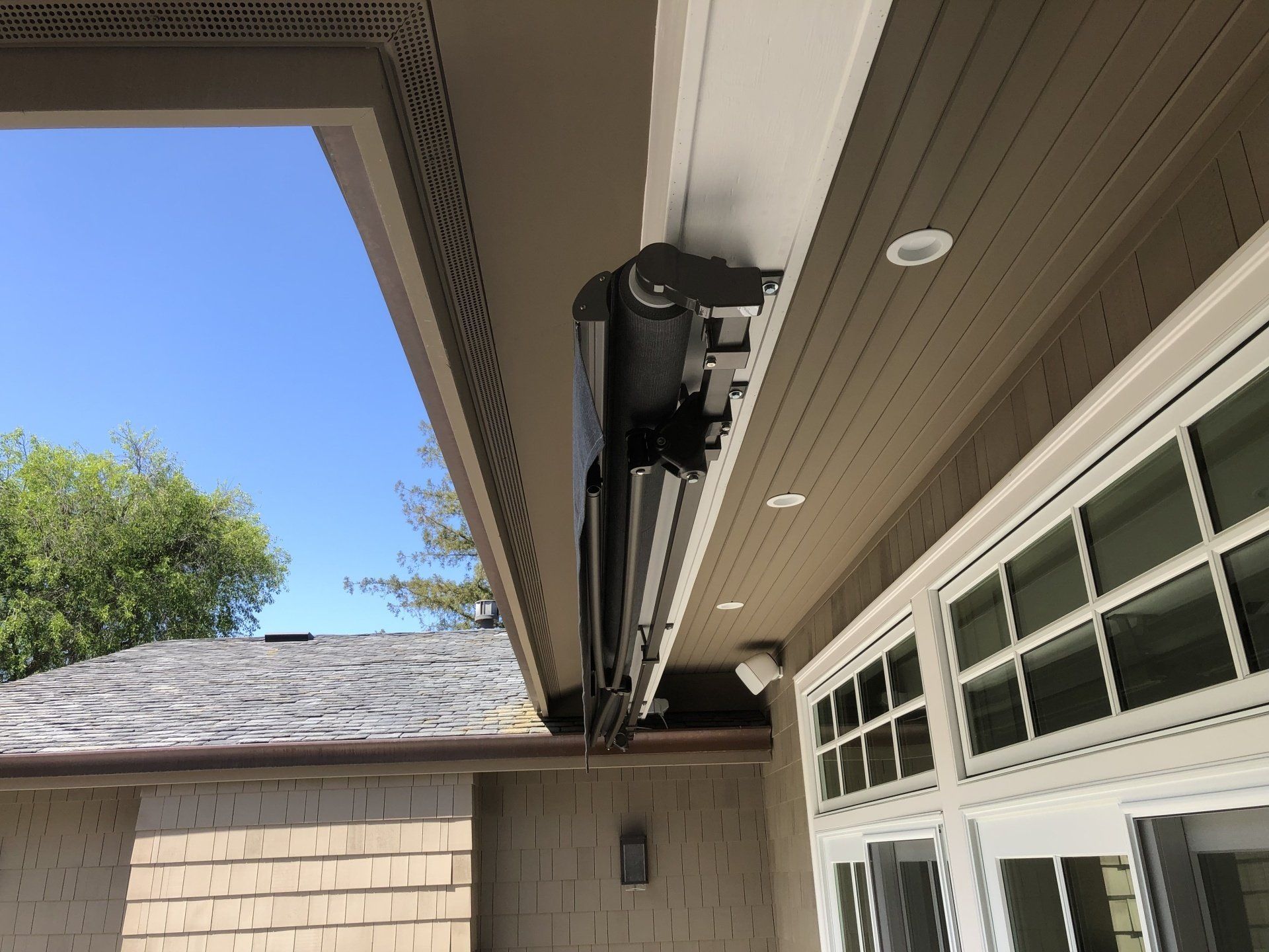 A black awning is hanging from the ceiling of a house.