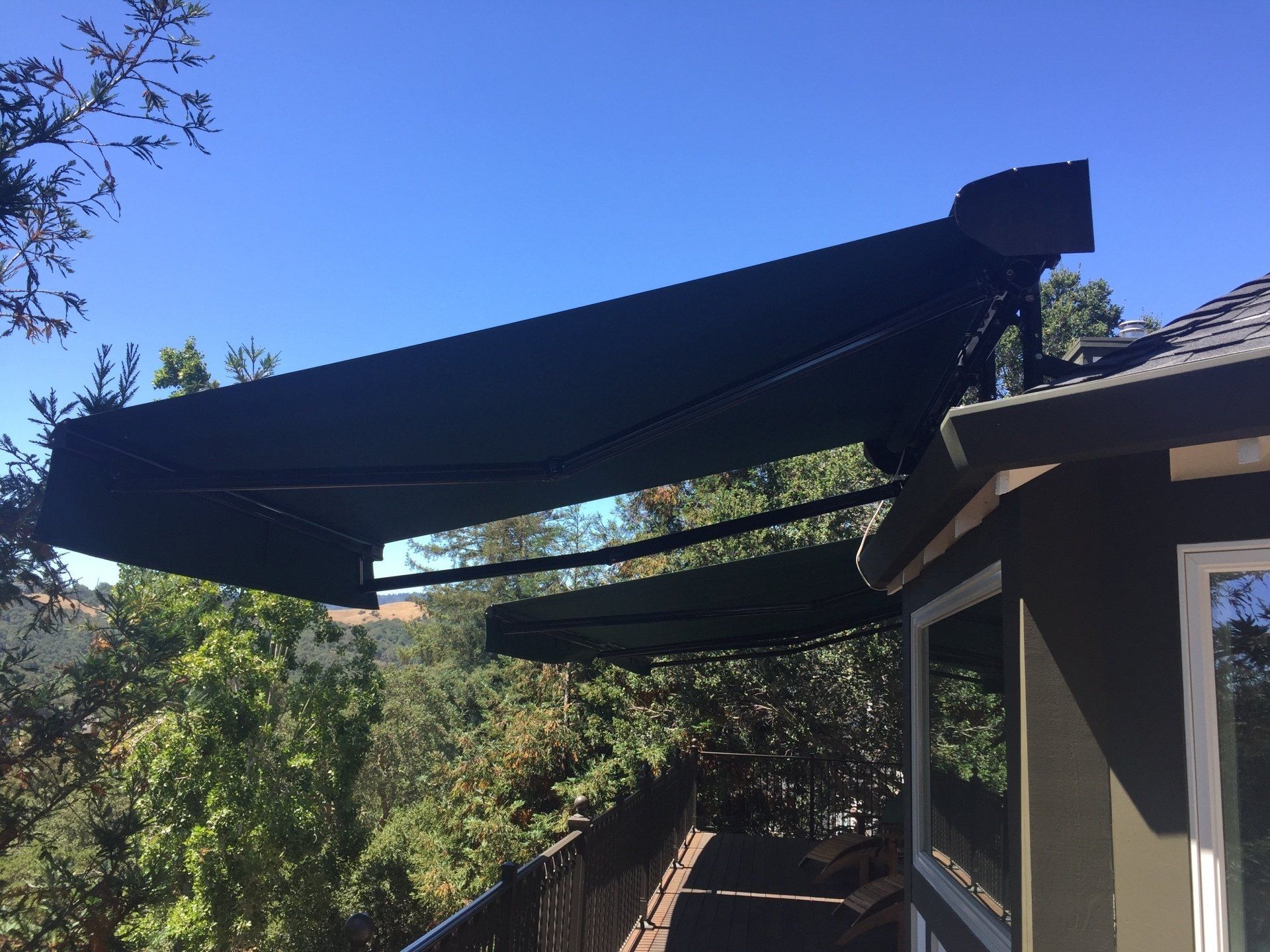 A black awning is sitting on the side of a house.