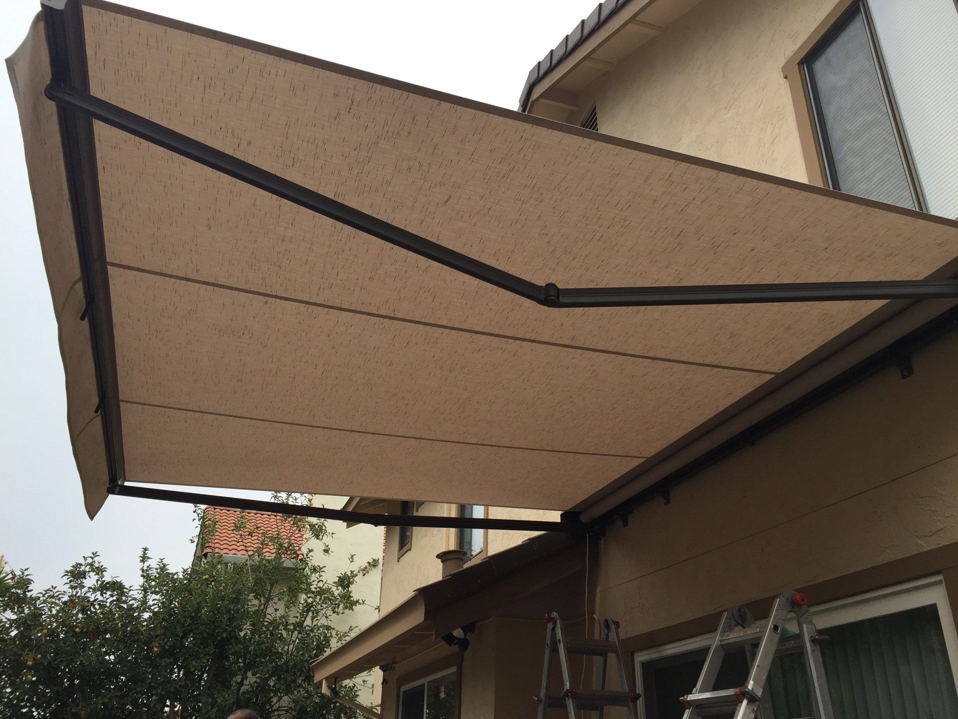 An awning is being installed on the side of a house