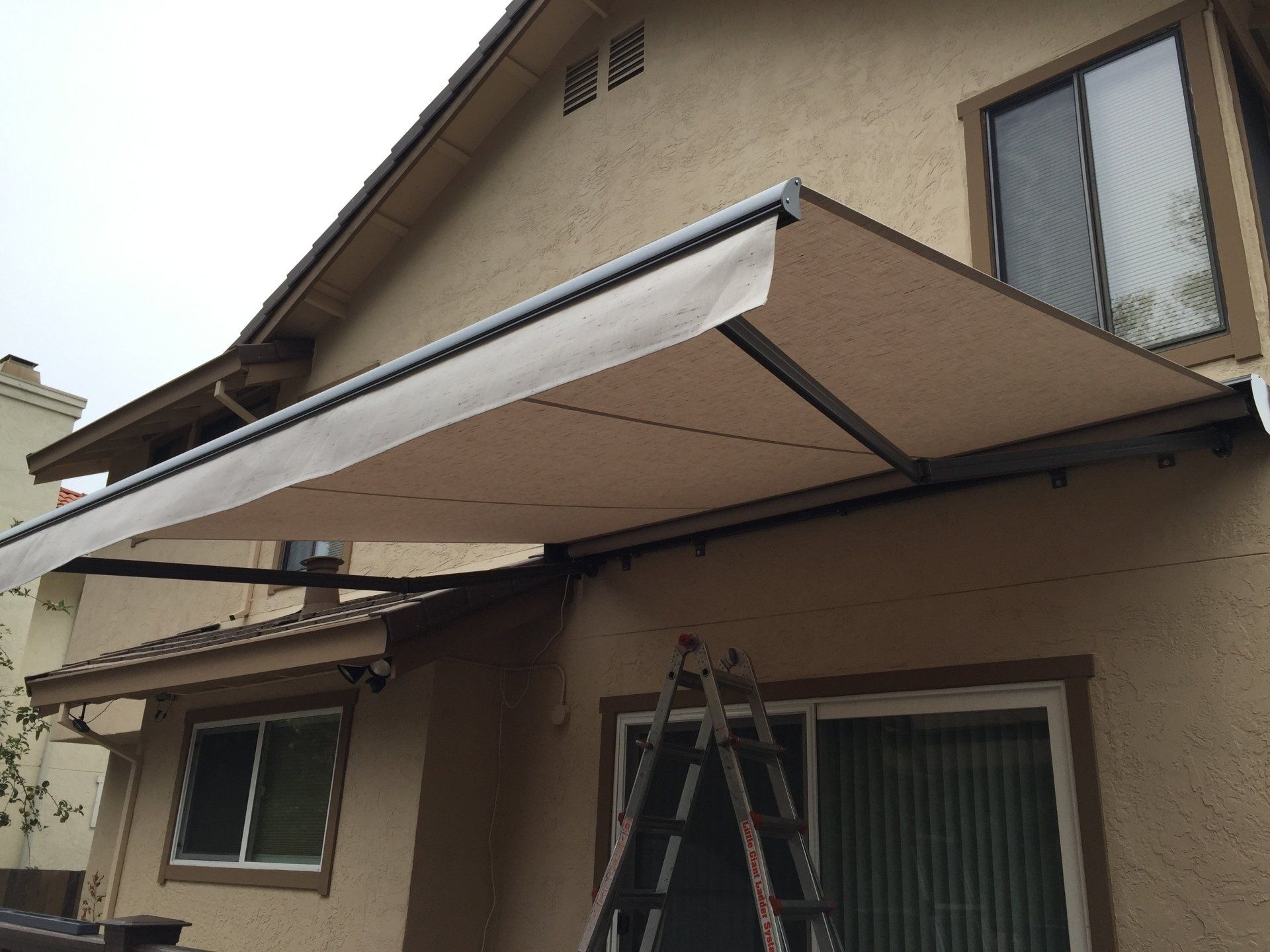A house with a white awning on the side of it
