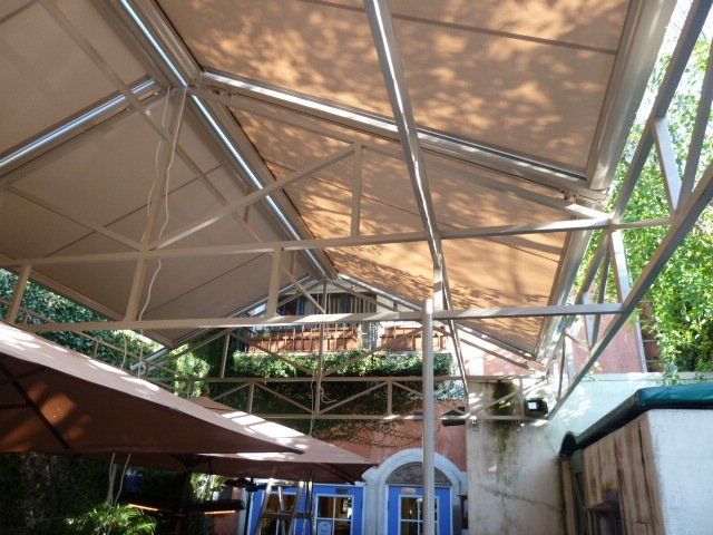 A building with a roof that is covered with umbrellas