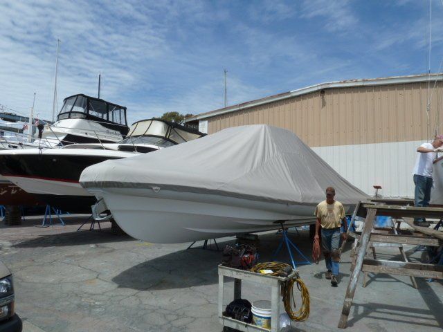 A man standing next to a boat with a cover on it