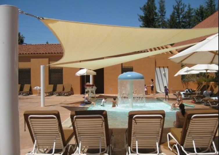 A swimming pool with chairs and umbrellas under a canopy