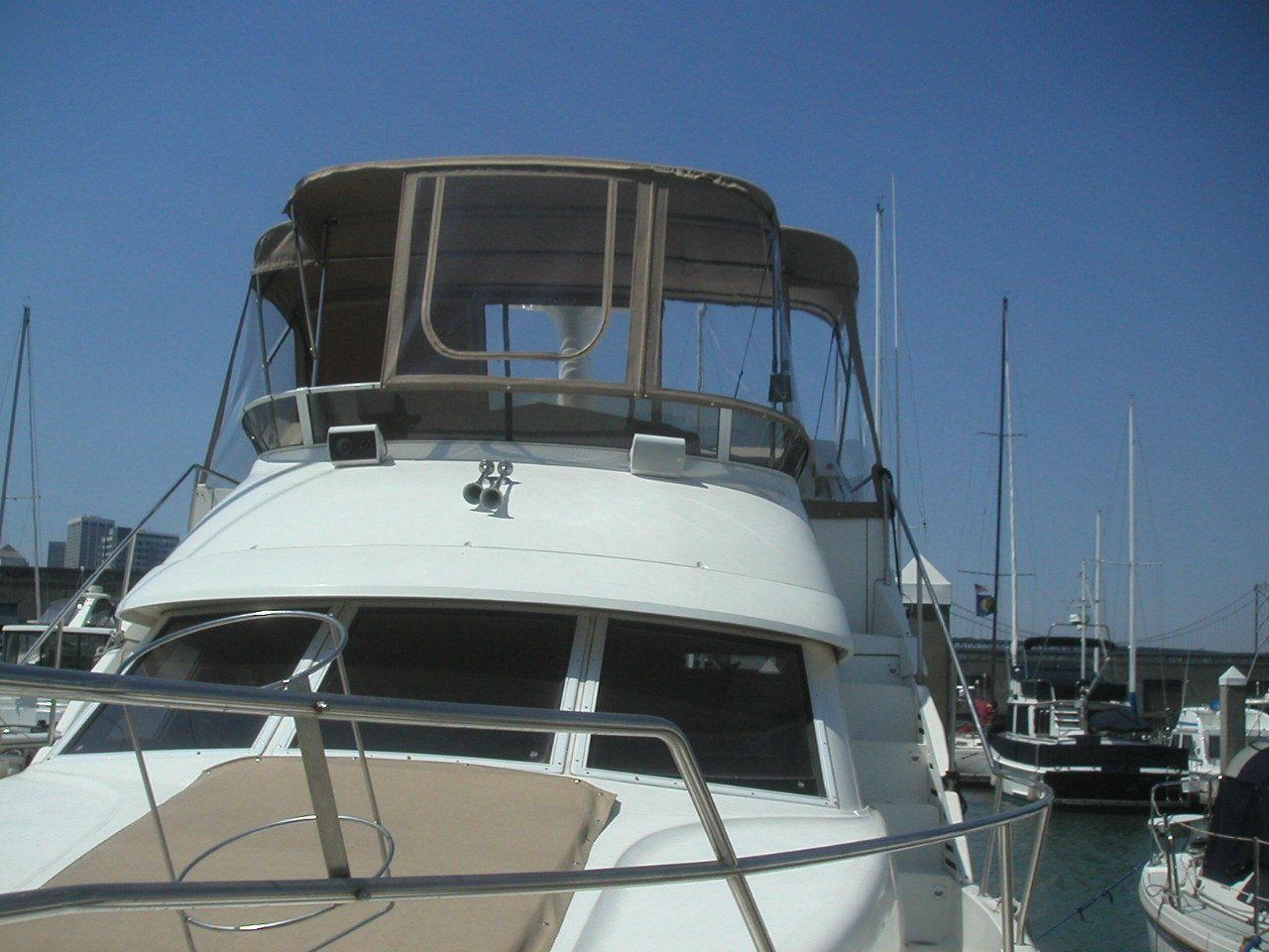 A boat with a canopy is docked in a marina