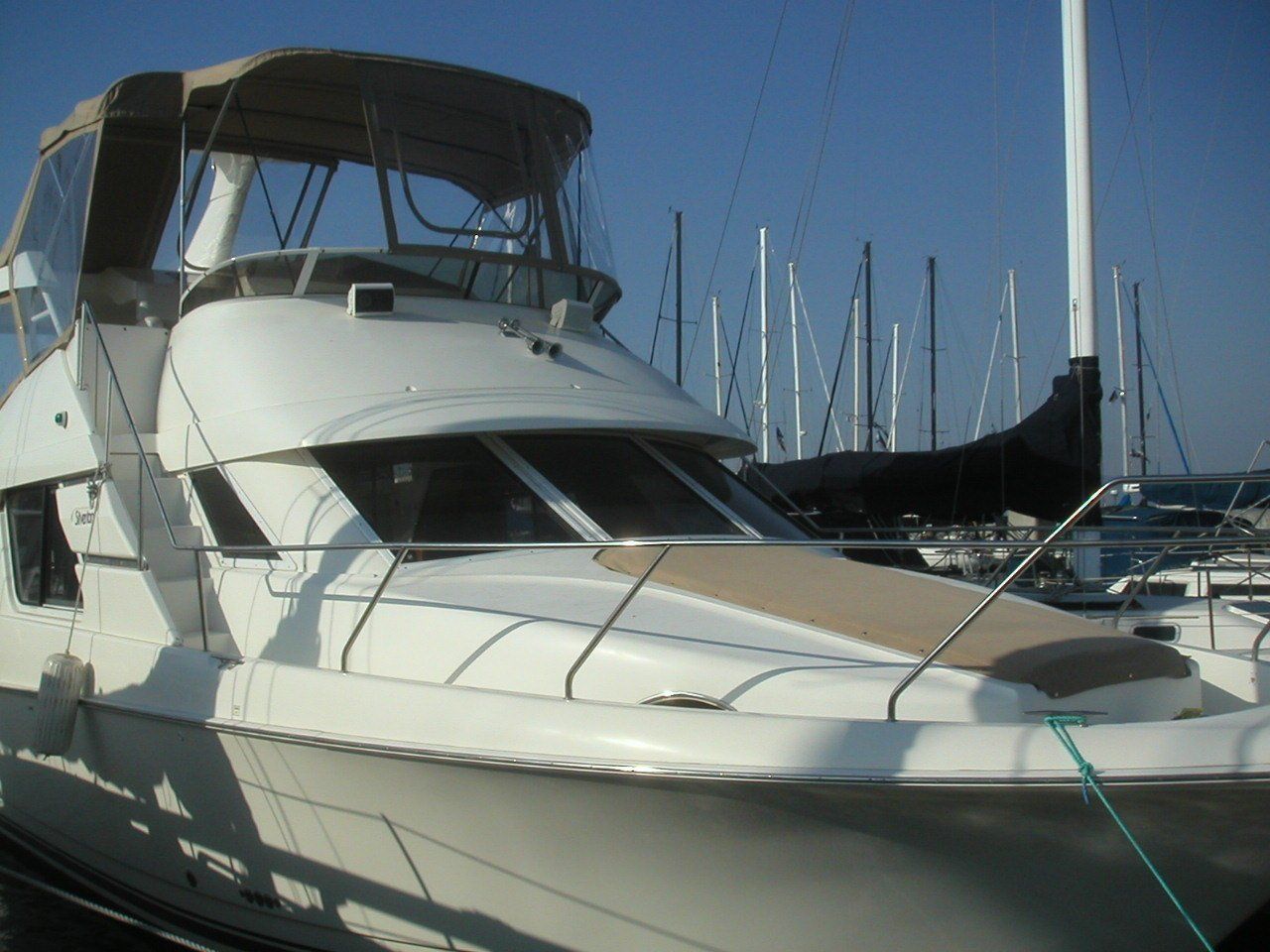 A large white boat is docked in a marina