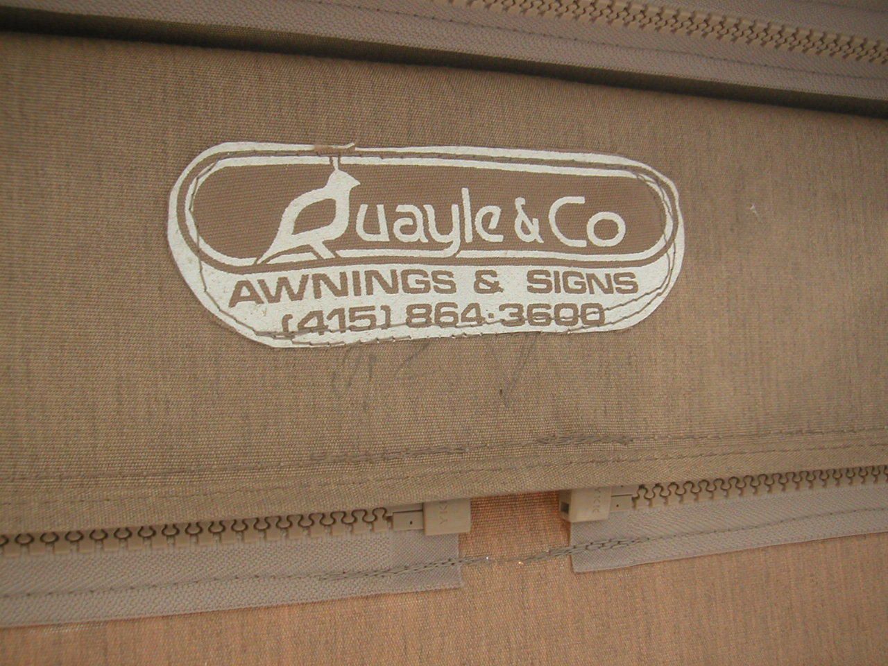 A sign for quayle & co awnings and signs