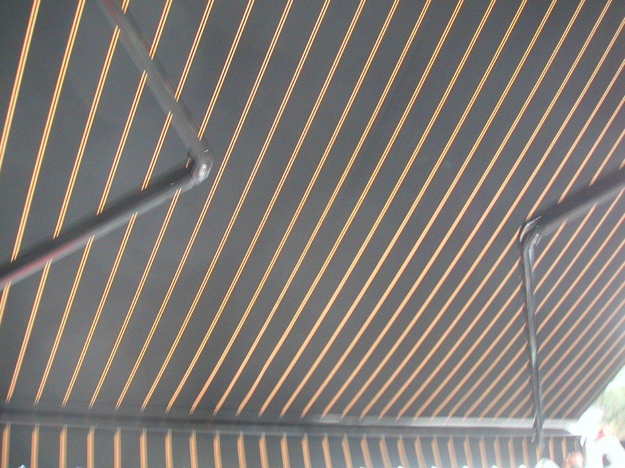 A black and gold striped awning with a metal frame