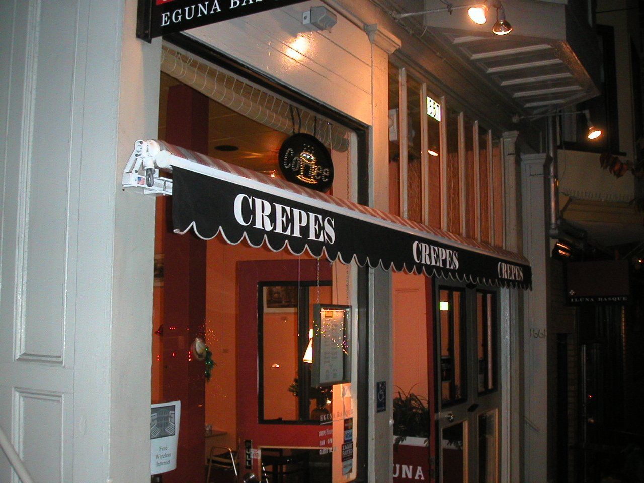 A restaurant with an awning that says crepes on it