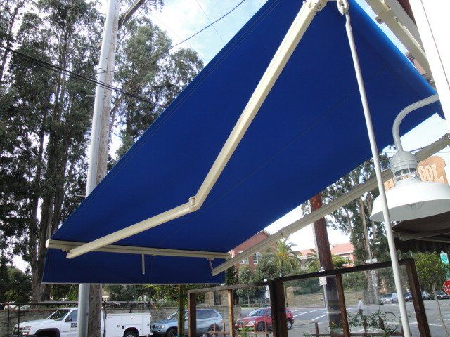 A blue awning is hanging from the side of a building