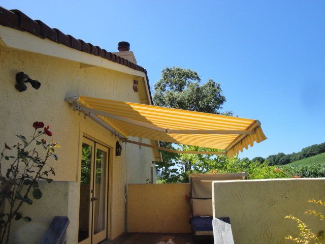 A yellow awning is on the side of a house