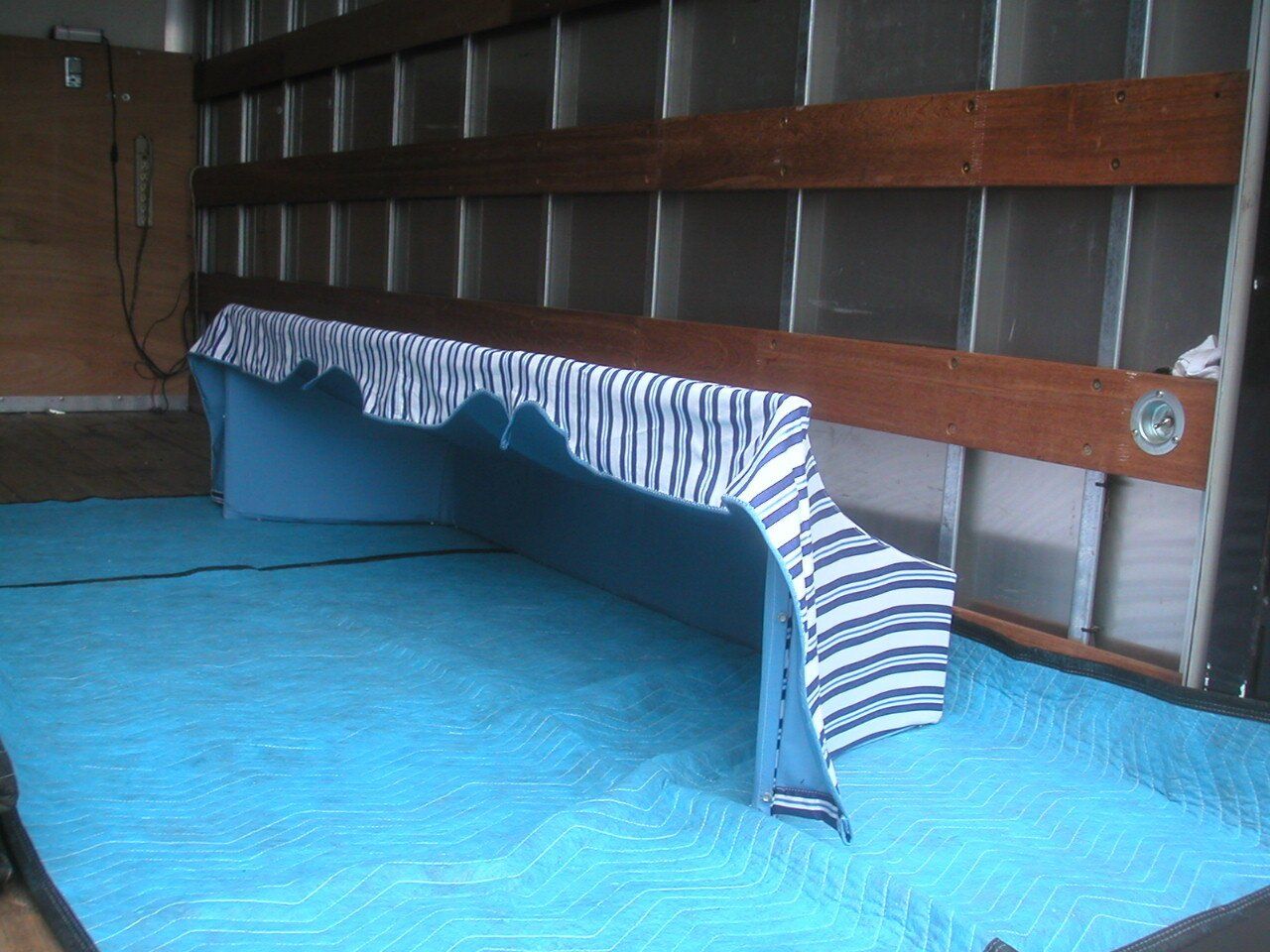 A blue and white striped piece of fabric is laying on a blue mat