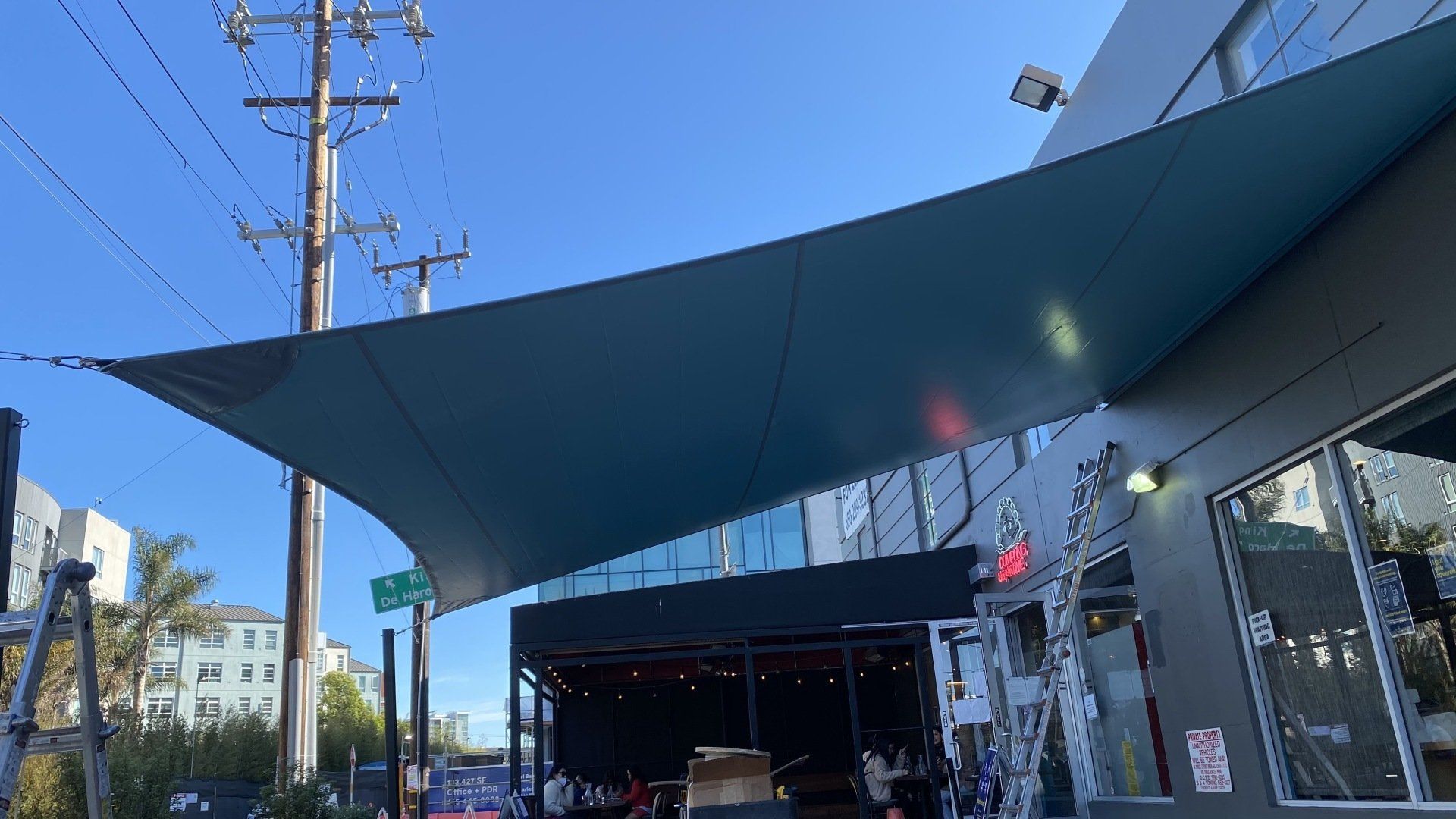 A large umbrella is covering the entrance to a restaurant.
