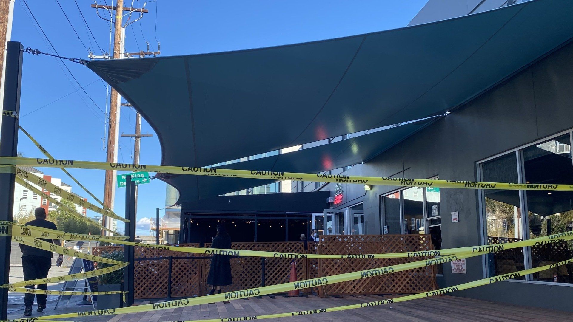 A large umbrella is surrounded by yellow tape.