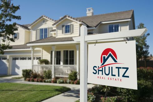 A house with a Shultz Real Estate sign in front of it