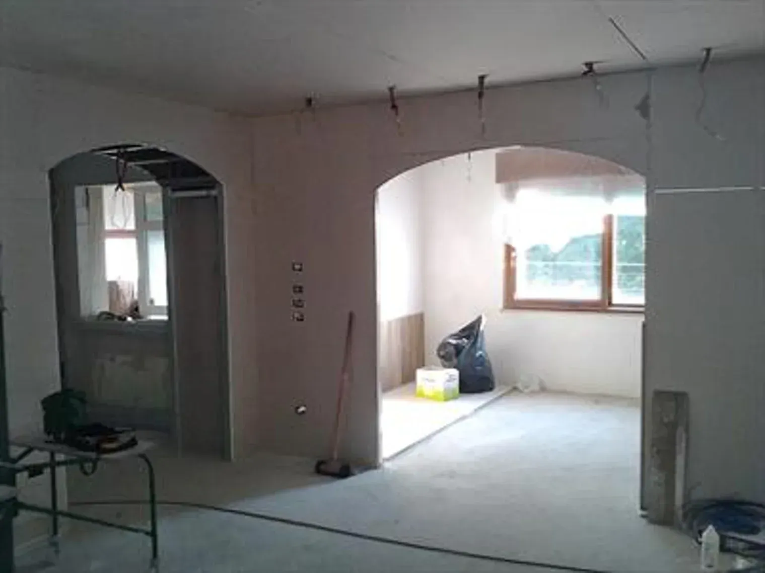 Interno in costruzione con archi e cavi elettrici a vista.