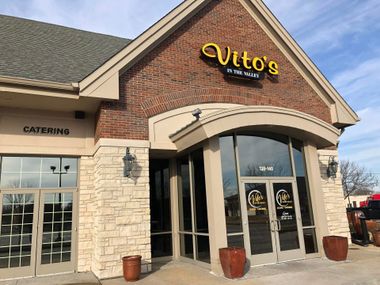 Vito’s restaurant entrance with brick facade, arched doorway, and glass doors under a tan roof