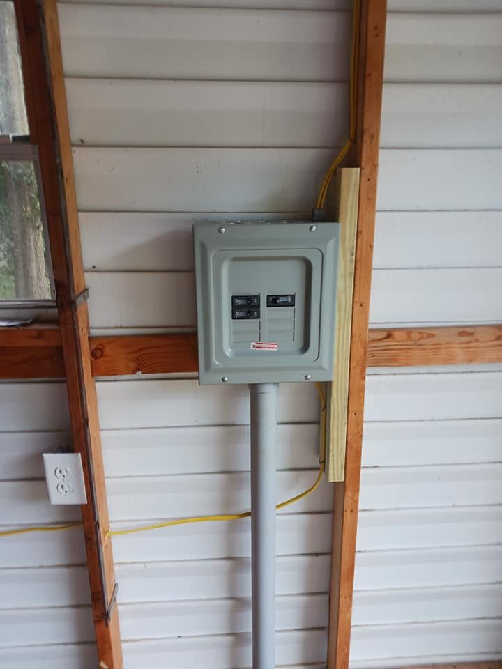 Electrical panel mounted on a wall inside a building; conduit runs to the panel.
