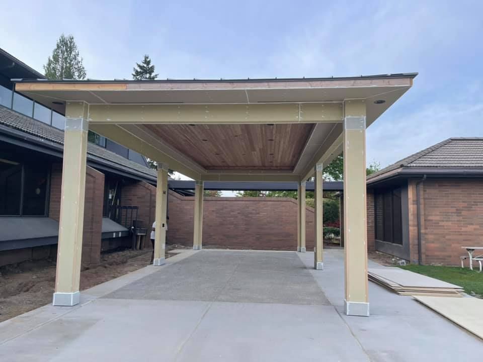 A carport is being built in the backyard of a house.