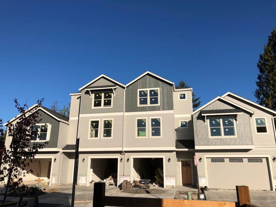 A row of houses under construction with a blue sky in the background.