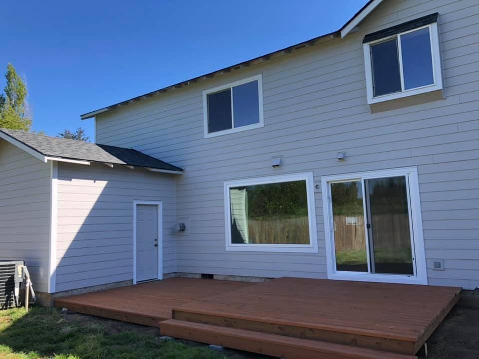 The back of a house with a wooden deck and sliding glass doors
