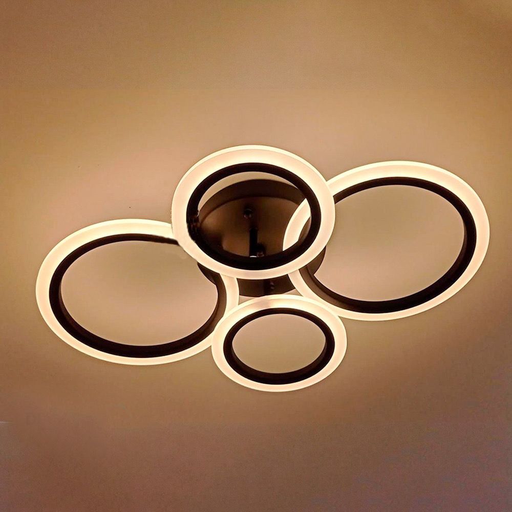 Lámpara de techo moderna con cuatro anillos ovalados iluminados superpuestos.