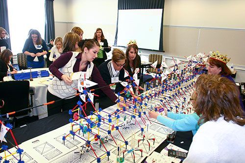 People working collaboratively on a complex building project model in a conference setting.