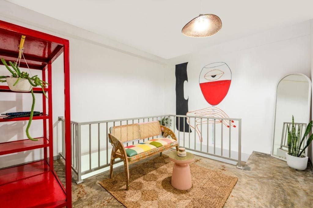 Loft with red shelving, a wicker sofa, rug, and art on the wall.