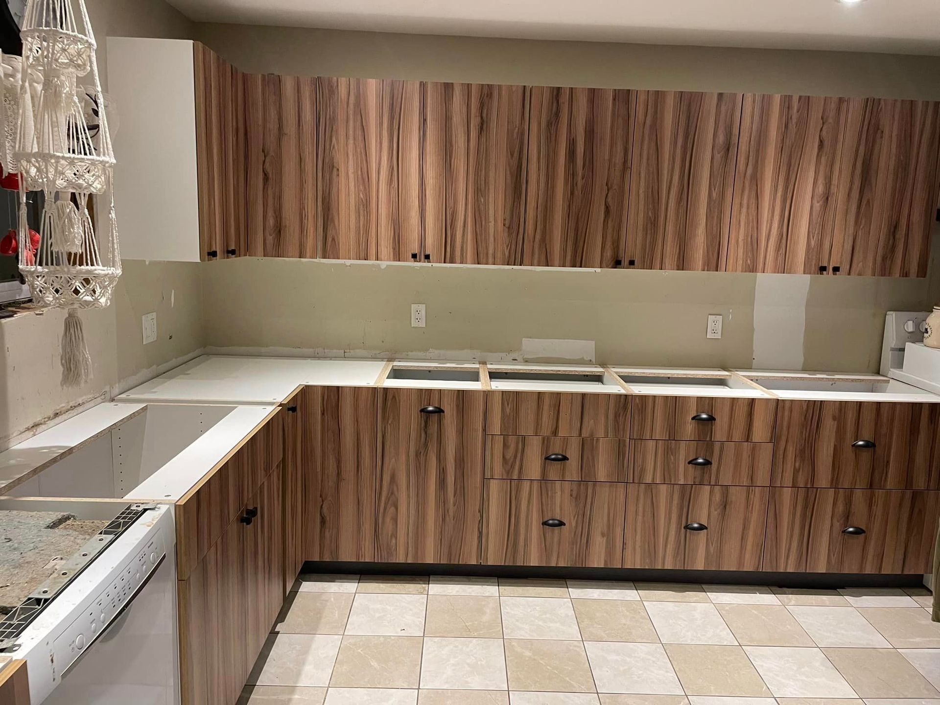 A kitchen with wooden cabinets and white counter tops